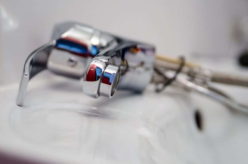 Disassembled kitchen faucet laying on countertop, highlighting plumbing maintenance during water damage prevention_unified Restoration
