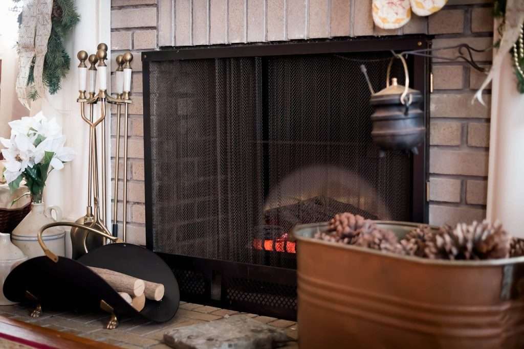 Cozy fireplace with a burning wood log, highlighting the importance of fire safety and proper fireplace maintenance