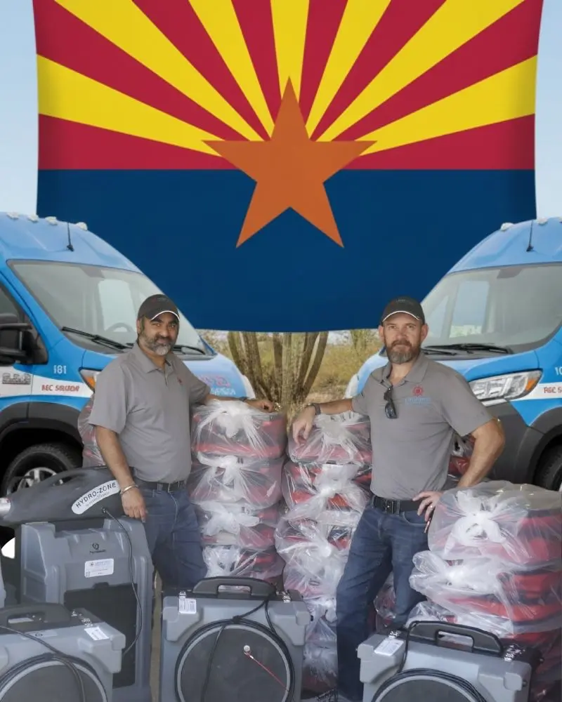 Water Damage Tolleson AZ — Unified Restoration LLC co-founders standing with two fully wrapped service vans, Hydro-Zone dehumidifiers, air movers, and restoration equipment in front of the Arizona state flag — family-owned restoration company based in Mesa, AZ