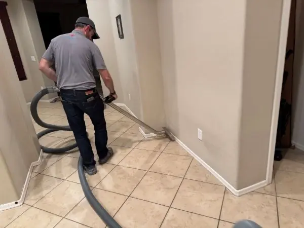 Unified Restoration LLC technician operating professional water extraction on water-damaged tile flooring in an Arizona residential job in Peoria, AZ