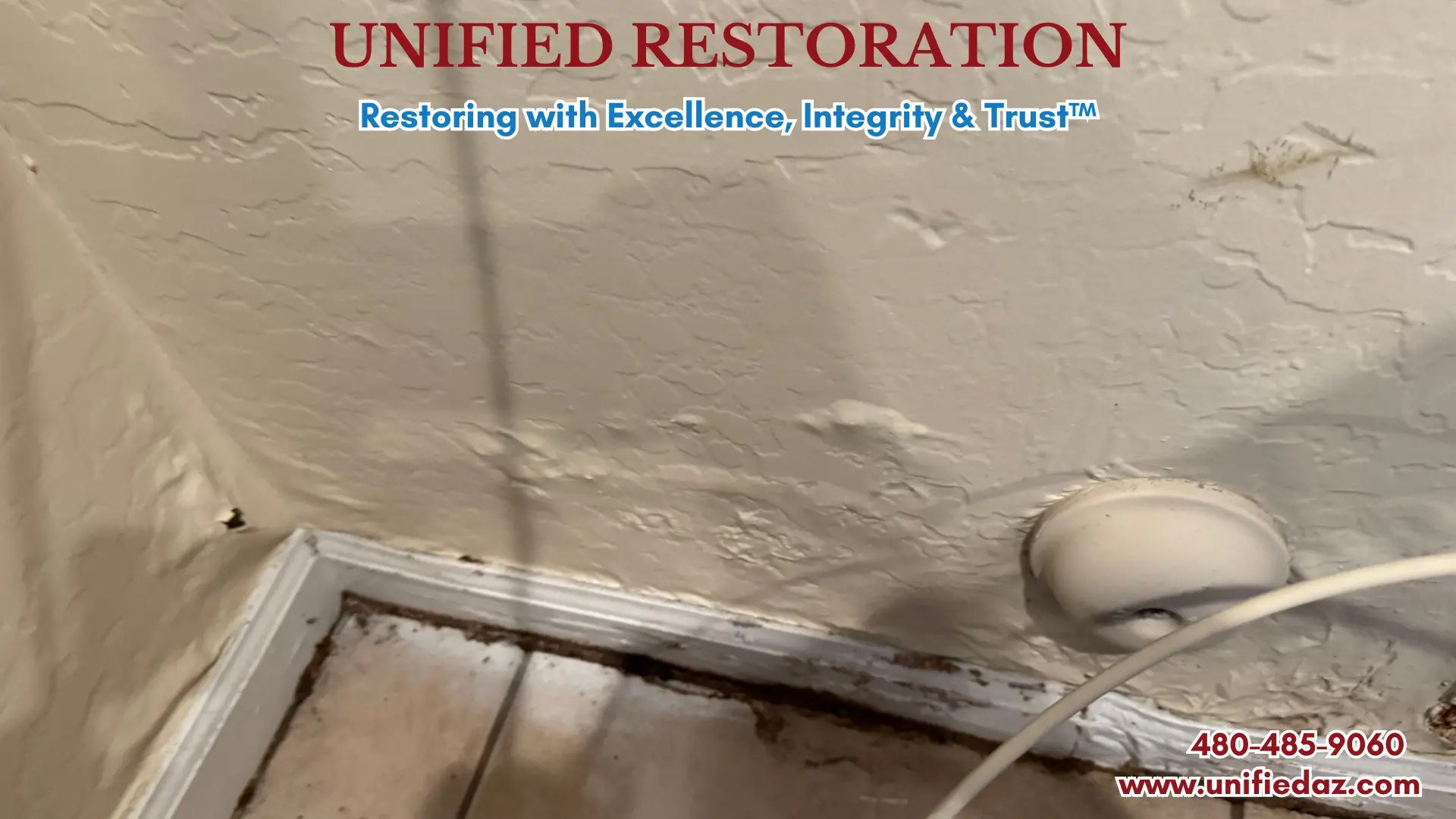 Real job photo showing hidden water damage behind a refrigerator in an Arizona kitchen — severely bubbled and warped drywall wall surface, dark mold growth along the baseboard and floor junction, and a refrigerator water supply line visible, indicating a slow leak behind the appliance requiring professional water damage restoration